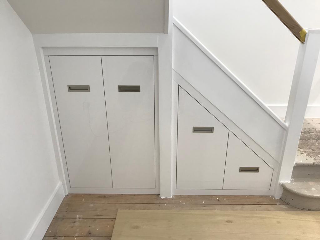 Белый распашной шкаф под лестницей с врезными ручками S107