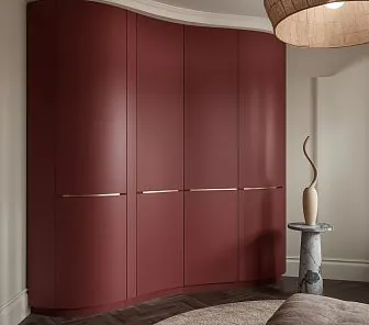 Радиусный шкаф в цвете глубокий бордо с золотистыми ручками