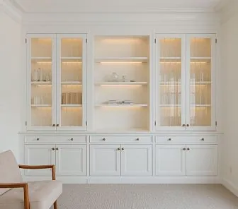 Белая встроенная библиотека с витринами и подсветкой