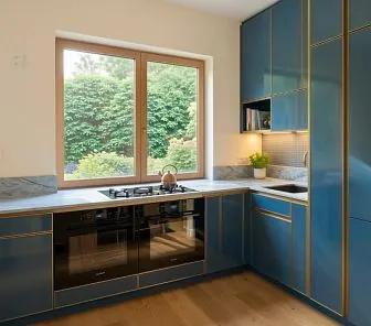 Угловая глянцевая синяя кухня в стиле ар-деко с латунными молдингами и мраморной столешницей